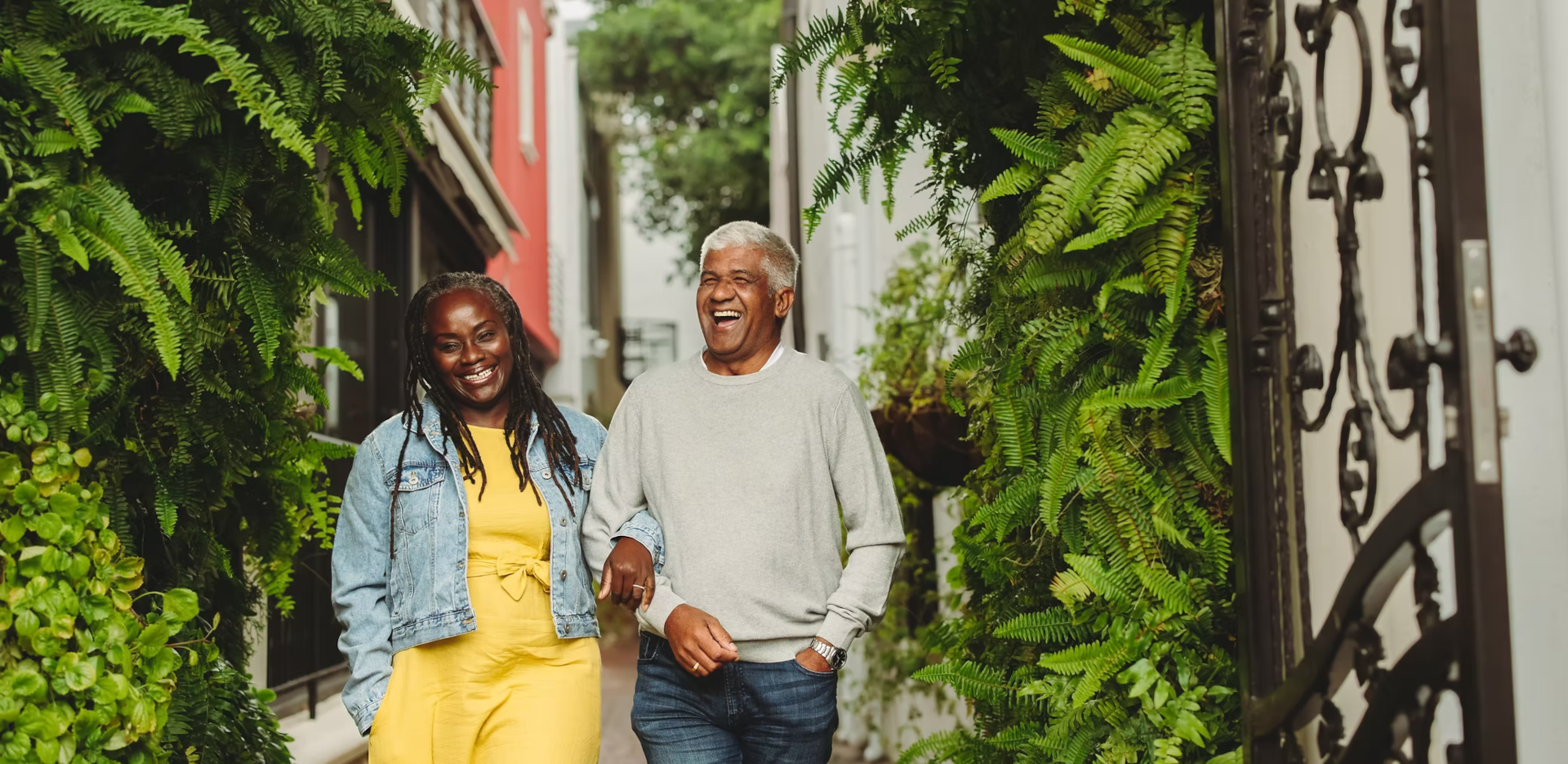 black man and woman arm in arms similing and laughing1920 935